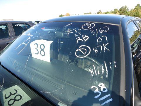 2001 Ford Crown Victoria - Handwritten markings on the windshield of a black sedan, including the year '07' and mileage '87K'.