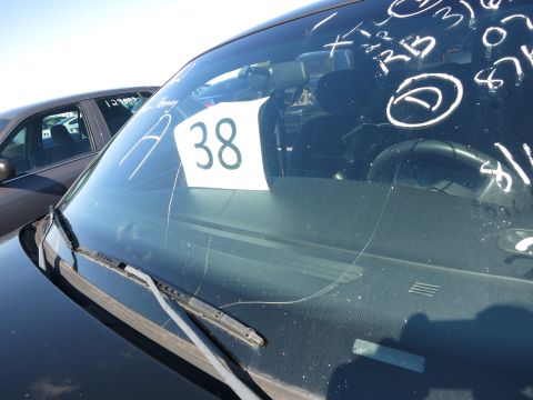2001 Ford Crown Victoria - Windshield with markings and a tag showing the number 38, with another car in the background.