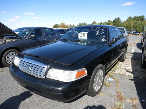 2001 Ford Crown Victoria - A black Ford Crown Victoria is parked outside with its hood open, showing visible markings on the windshield.