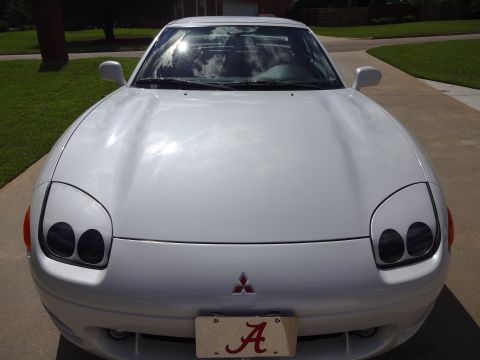 1995 Mitsubishi 3000GT - Front view of a white 1995 Mitsubishi 3000GT, the distinctive headlights and Mitsubishi emblem.