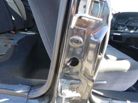 2001 Ford Crown Victoria - Close-up view of a car's interior door jamb, revealing exposed wiring and grey upholstery.