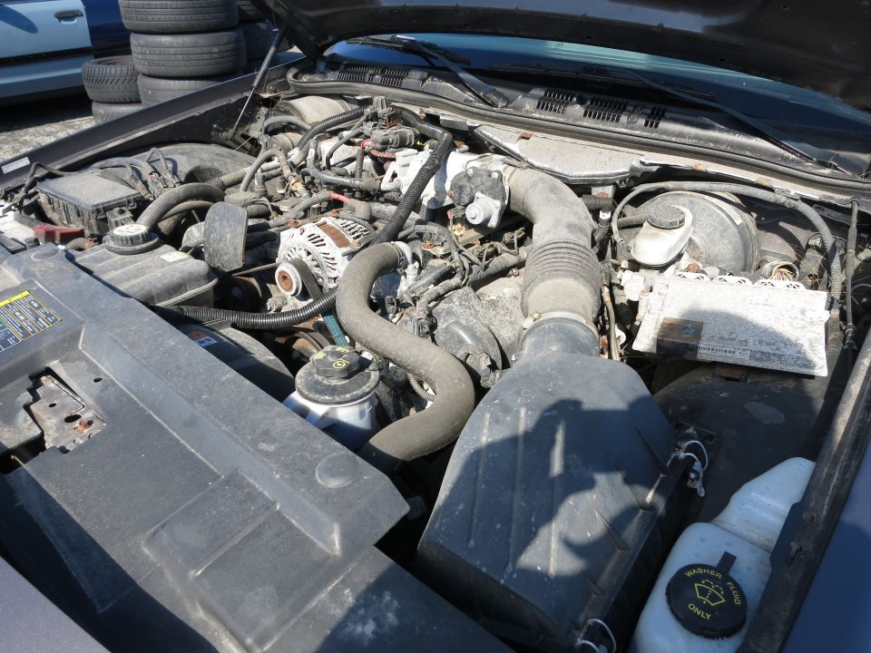 2001 Ford Crown Victoria engine bay with alternator, air intake, and fluid reservoirs visible
