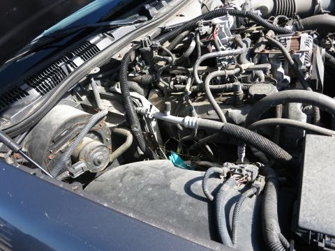 2001 Ford Crown Victoria - The engine bay of a vehicle is shown, with various mechanical parts and wiring harnesses.