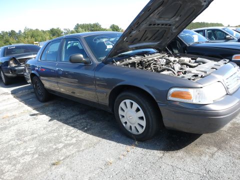 2001 Ford Crown Victoria - A dark gray 2001 Ford Crown Victoria sedan is parked outside with its hood open, revealing the engine compartment.