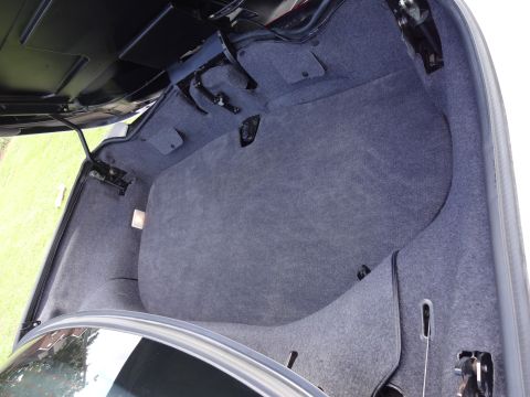 1995 Mitsubishi 3000GT - The carpeted trunk interior shows the mechanism for the trunk lid.