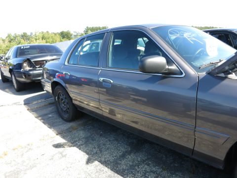 2001 Ford Crown Victoria - Two Ford Crown Victorias are parked side-by-side in an outdoor lot.
