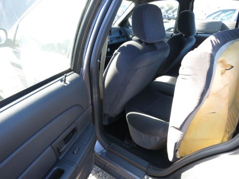 2001 Ford Crown Victoria - The interior of a car is shown, with a focus on the rear seating area and the driver's side door panel.
