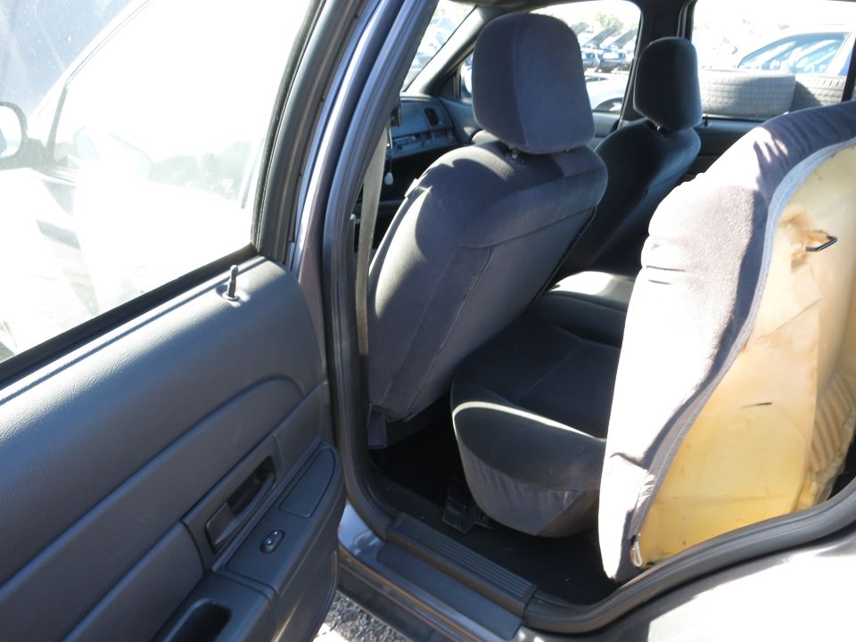 Interior view of a car showing the back seats and door panel. One seat cushion is partially removed