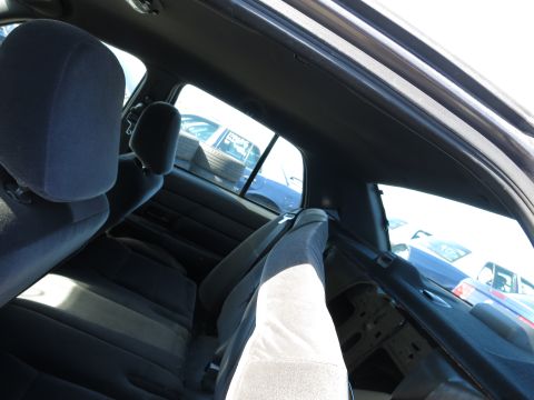 2001 Ford Crown Victoria - Interior view of a dark sedan, showing the rear seats and a glimpse of other vehicles outside.