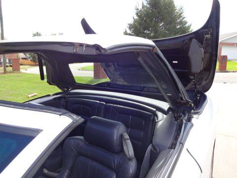 1995 Mitsubishi 3000GT - The complex mechanism of the 1995 Mitsubishi 3000GT's retractable hardtop is visible with the top partially open.
