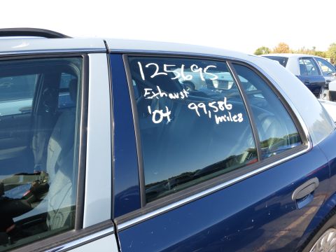 2001 Ford Crown Victoria - A blue and silver sedan is seen from the side, with handwritten notes on the window indicating '04 and 99,586 miles.