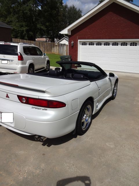 1995 Mitsubishi 3000GT - White 1995 Mitsubishi 3000GT convertible parked in front of a garage, with an SUV to the left.
