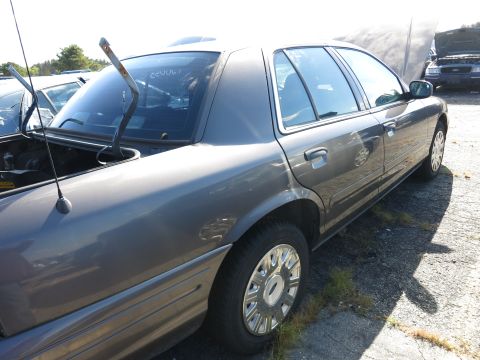 2001 Ford Crown Victoria - This 2001 Ford Crown Victoria is seen from the side with its hood open, parked in a lot with other vehicles.