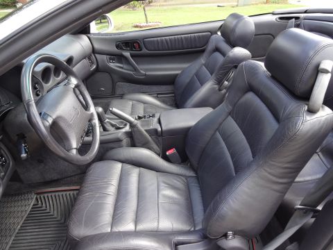 1995 Mitsubishi 3000GT - The interior of this convertible sports car features black leather seats and a detailed dashboard.