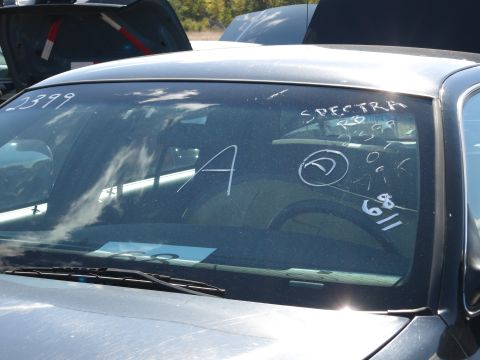 2001 Ford Crown Victoria - White markings are scrawled on the windshield of a sedan, obscuring any year identification.