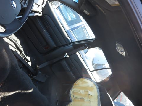 2001 Ford Crown Victoria - The interior of a police car shows wear and tear, with exposed foam on the passenger seat.