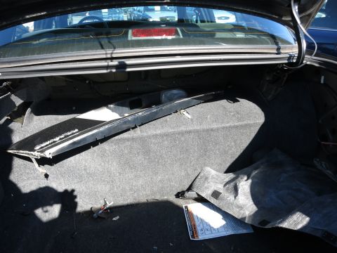 2001 Ford Crown Victoria - View inside a car's trunk, showing the carpeted floor and a detached plastic trim piece.