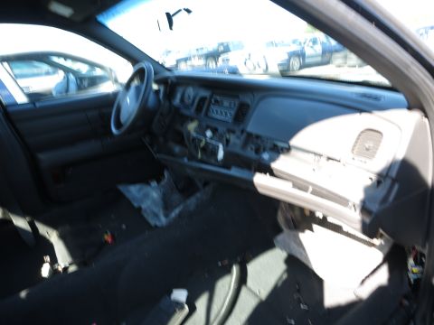 2001 Ford Crown Victoria - The interior of a car shows a disassembled dashboard and an open glove compartment.