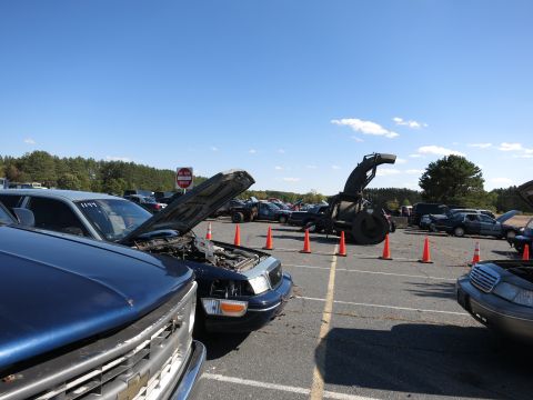 2001 Ford Crown Victoria - A parking lot scene with multiple vehicles, including a 2001 Ford Crown Victoria, under a clear blue sky.