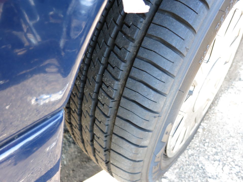 Close-up of a blue car's tire and fender