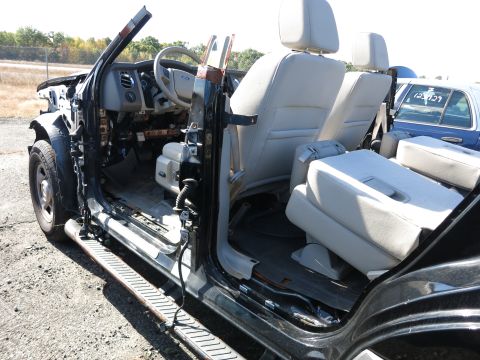 2001 Ford Crown Victoria - The interior of a heavily damaged black SUV is visible, with a blue car in the background.