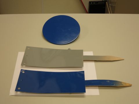 1991 Ford LTD Crown Victoria - Two painted metal stakes and a blue disc are laid out on a table.