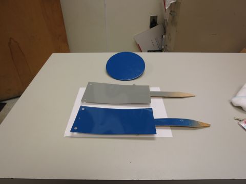 1991 Ford LTD Crown Victoria - Two flat metal objects with wooden handles and a blue circular object are displayed on a table.
