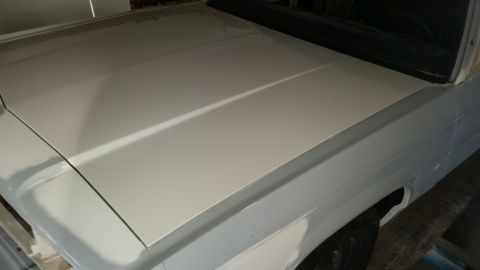 1991 Ford LTD Crown Victoria - The hood and fender of a 1991 Ford Crown Victoria LTD are visible, with primer applied in preparation for paint.