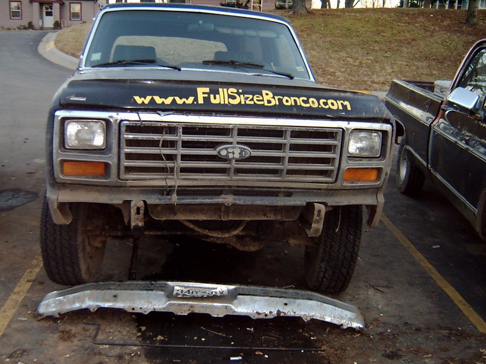 Black lifted Ford truck with FullSizeBronco.com decal, bumper removed and lying on ground