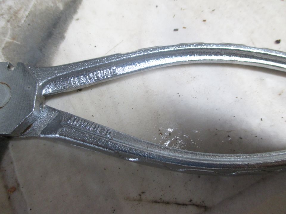Close-up of pliers with "HAPENED" and "GERMANY" stamped on them