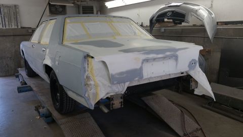 1991 Ford LTD Crown Victoria - A sedan is being prepped for paint in a workshop, showing extensive body repairs.