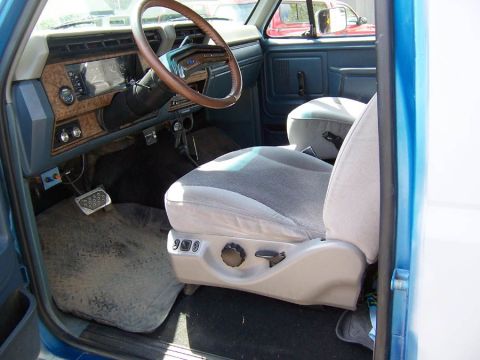 1983 Ford Bronco - Driver side Ford Excursion seat, gray interior trim, wet oil pressure gauge, vacuum gauge, tilt column, under hood and fog light switches.