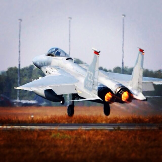 Fighter jet with engines on fire, lifting off a runway