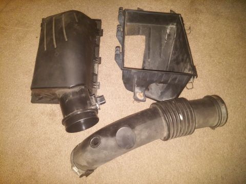 2000 Mercury Grand Marquis - Air intake system components laid out on a carpeted surface.