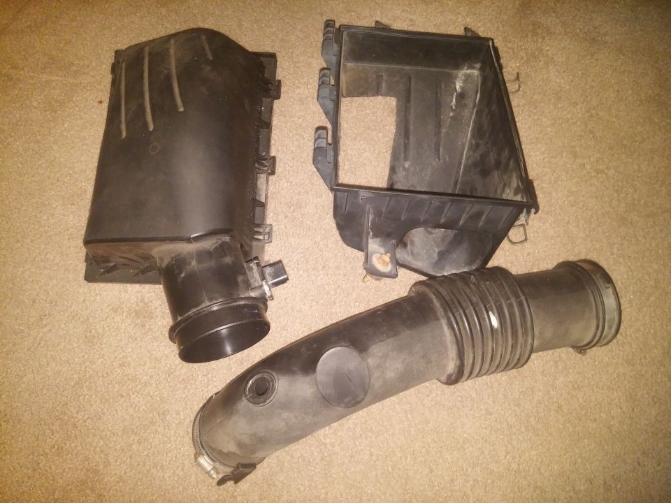 Air intake housing and hose parts on carpet