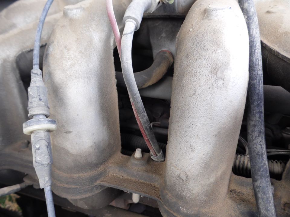 Close-up of engine intake manifold with hoses and wires
