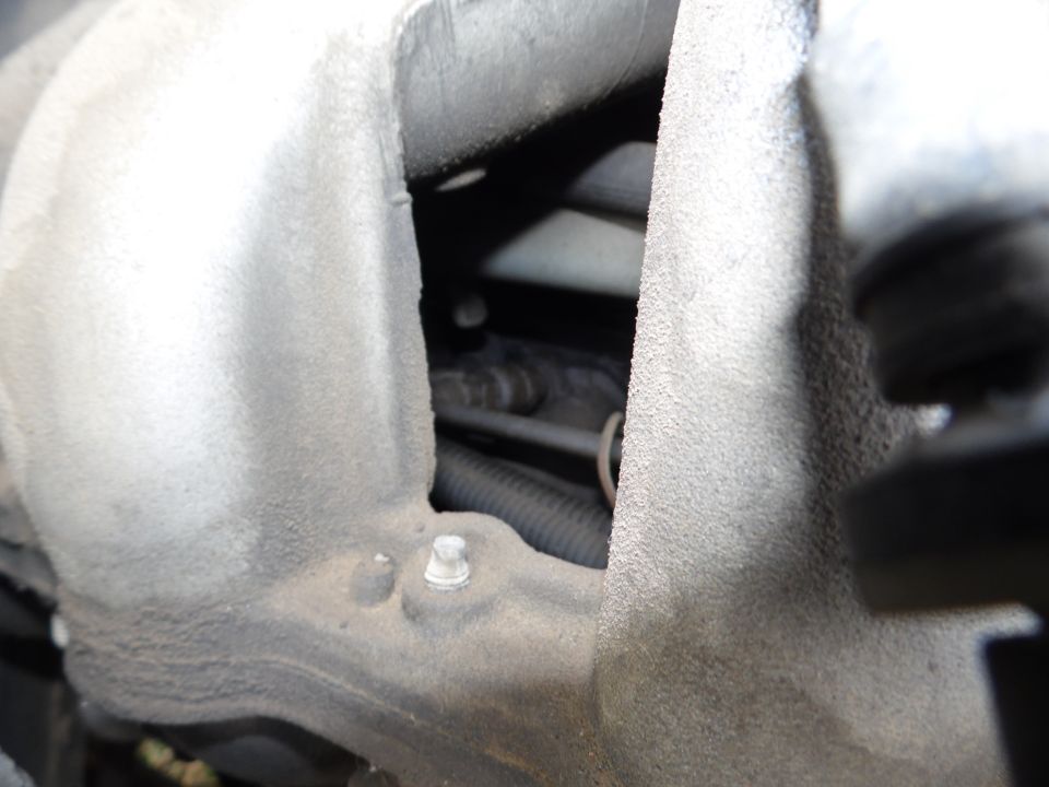 Engine intake manifold with visible bolts and hoses