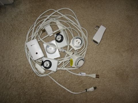 1994 Ford Bronco - Several mechanical and digital timers are tangled with their power cords on a carpeted surface.