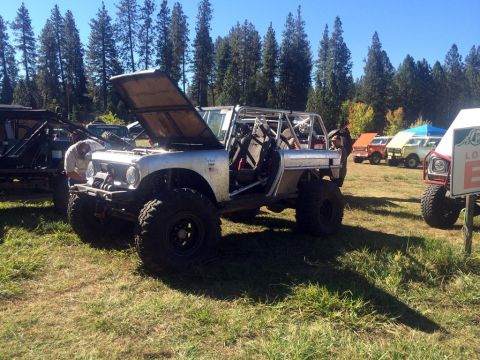 1961 International Scout 800 - A modified 1961 International Scout 800 is parked in a grassy field with other vehicles.