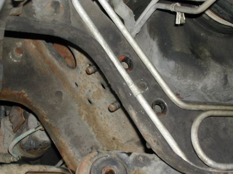 1996 Ford Bronco - Close-up view of the underbody suspension components, showing metal lines and bolts.