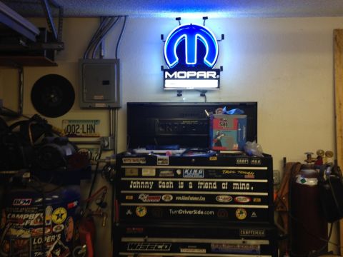 2010 Dodge Challenger - A garage scene a Mopar neon sign and a tool chest adorned with various stickers and memorabilia.