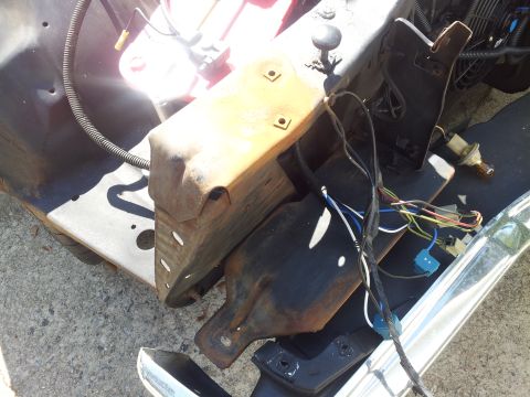 1976 Ford Ranchero - Close-up of disassembled vehicle components, including a rusty bracket and wiring.