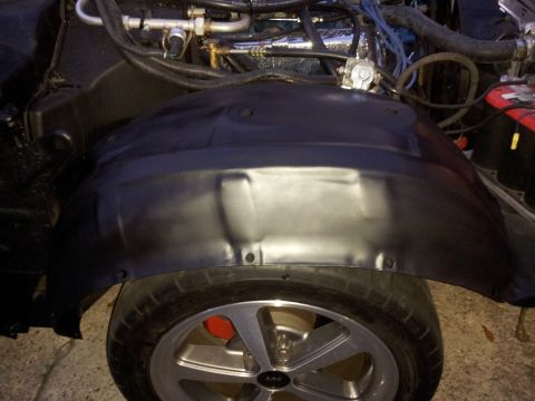 1976 Ford Ranchero - Close-up view of a vehicle's wheel well and exposed engine components.