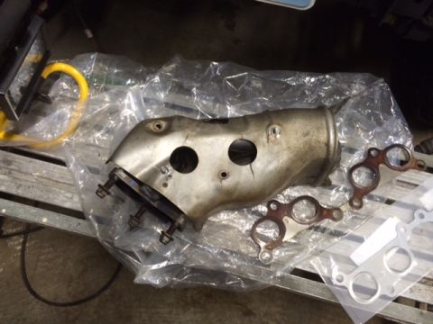 1988 Suzuki Samurai - A close-up view of an exhaust manifold and several gaskets, likely for a vehicle repair or upgrade.
