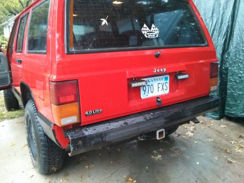 1986 Ford Bronco - This red Jeep Cherokee XJ is shown from the rear, a Kansas license plate and a 4.0 Litre badge.