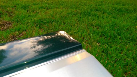 1996 Ford Bronco - A vehicle's tailgate, possibly from an older model, is shown resting on a grassy area.