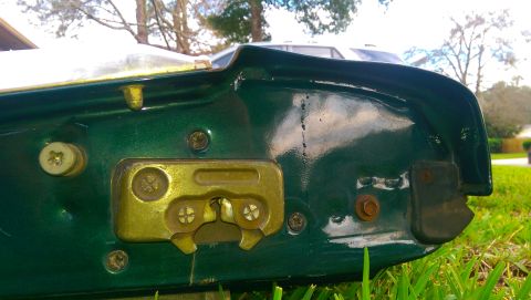 1996 Ford Bronco - Close-up of a green tailgate latch mechanism, showing the internal workings and mounting screws.