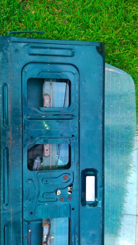 1996 Ford Bronco - Interior view of a teal tailgate, possibly from a Ford Bronco, with a visible Supermotors logo at the bottom.