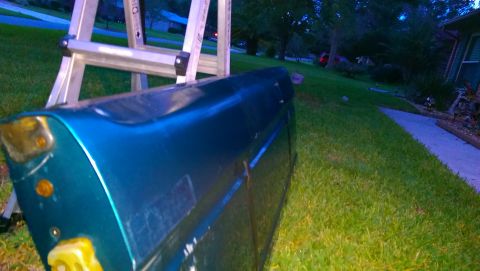 1996 Ford Bronco - A teal tailgate is propped against a ladder outdoors, with a residential setting visible in the background.