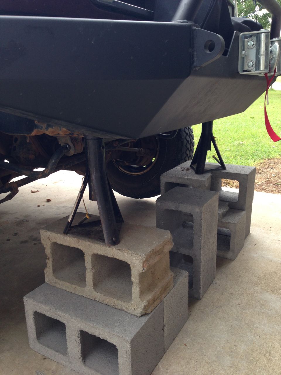 Rear bumper supported by jack stands and cinder blocks